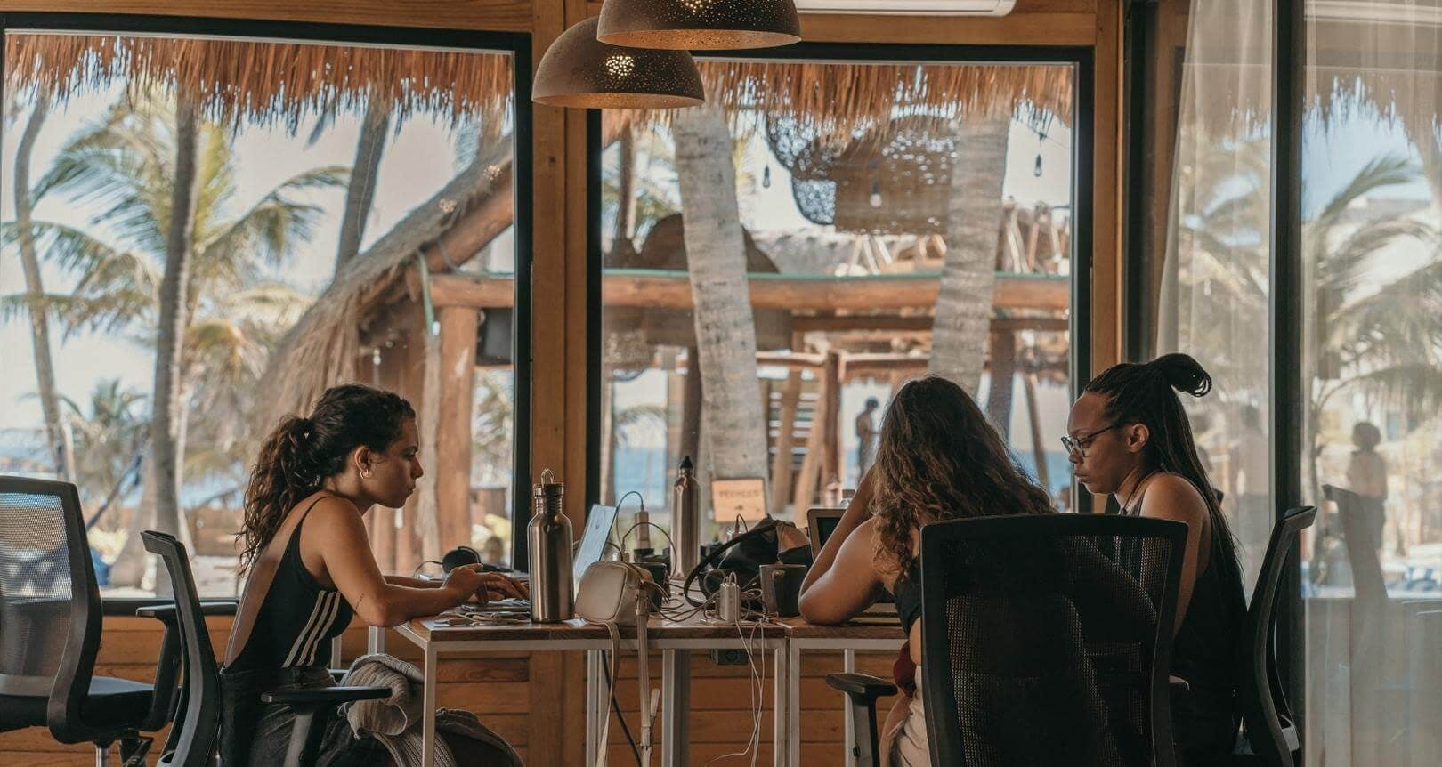 women remote working at beachside space