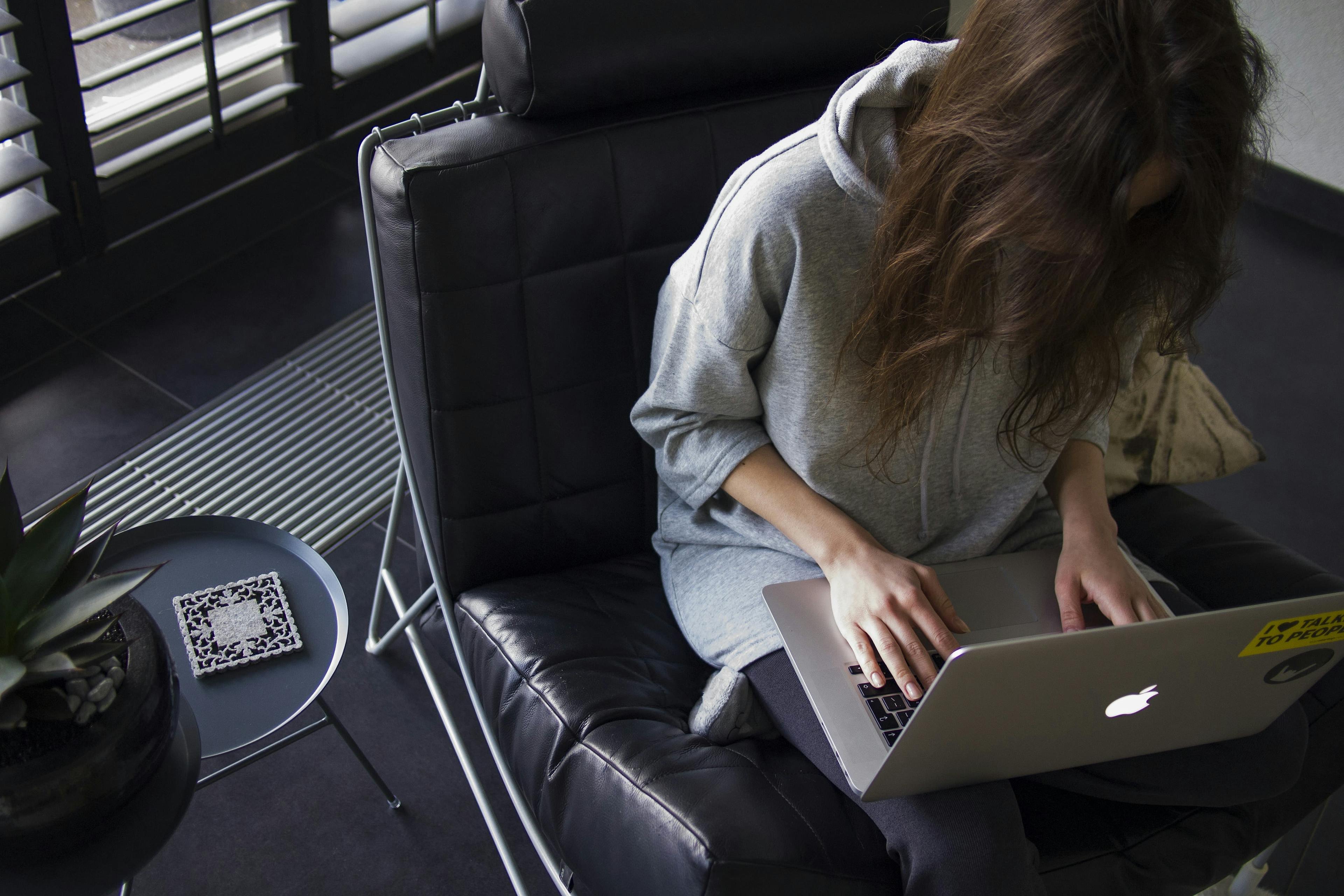 Girl sitting on chair, remote working on laptop