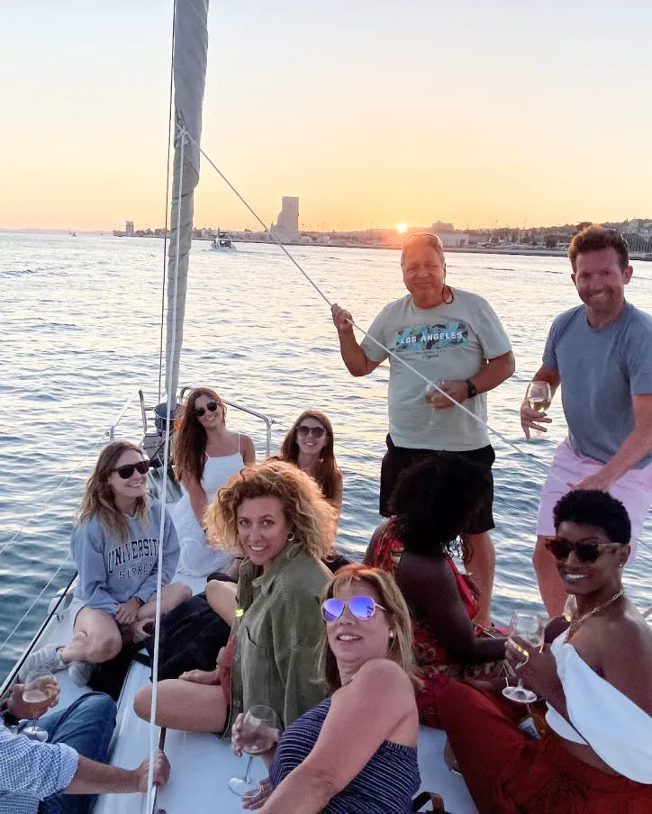 A group of remotes on a boat having fun with a sunset