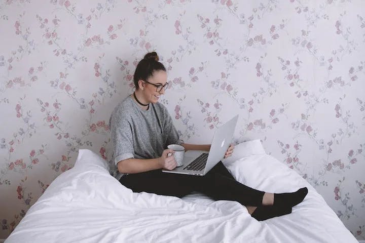 Girl working on laptop on bed