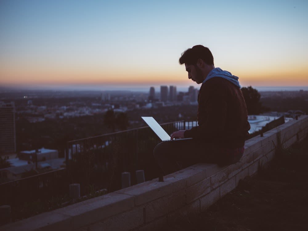 Man sitting with laptop with a view